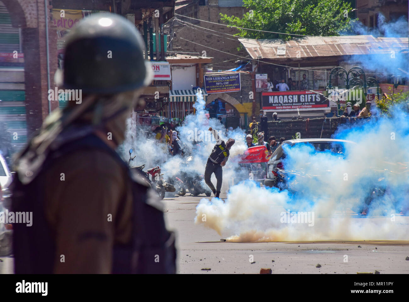 Un protestor Kashmir getta indietro un esploso di una lacerazione della shell di fumo verso la polizia durante scontri nella città vecchia di Srinagar capitale estiva del Kashmir indiano dopo la preghiera del venerdì. Scontri scoppiati subito dopo la preghiera del venerdì in area del centro cittadino di Srinagar, Kashmir indiano, il venerdì. Diverse persone sono rimaste ferite dopo che le forze governative hanno sparato pistole di pellet e gas lacrimogeni gusci su persone che si sono riuniti dopo venerdì pomeriggio le preghiere che protestavano contro la regola di indiana nella regione contesa. Foto Stock