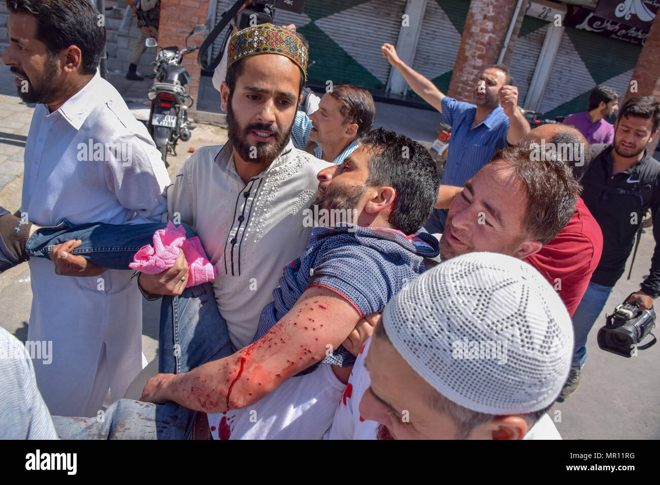 Persone che trasportano la persona ferita per il trattamento durante gli scontri tra le forze indiane e persone in Srinagar capitale estiva del Kashmir indiano. Scontri scoppiati subito dopo la preghiera del venerdì in area del centro cittadino di Srinagar, Kashmir indiano, il venerdì. Diverse persone sono rimaste ferite dopo che le forze governative hanno sparato pistole di pellet e gas lacrimogeni gusci su persone che si sono riuniti dopo venerdì pomeriggio le preghiere che protestavano contro la regola di indiana nella regione contesa. Foto Stock