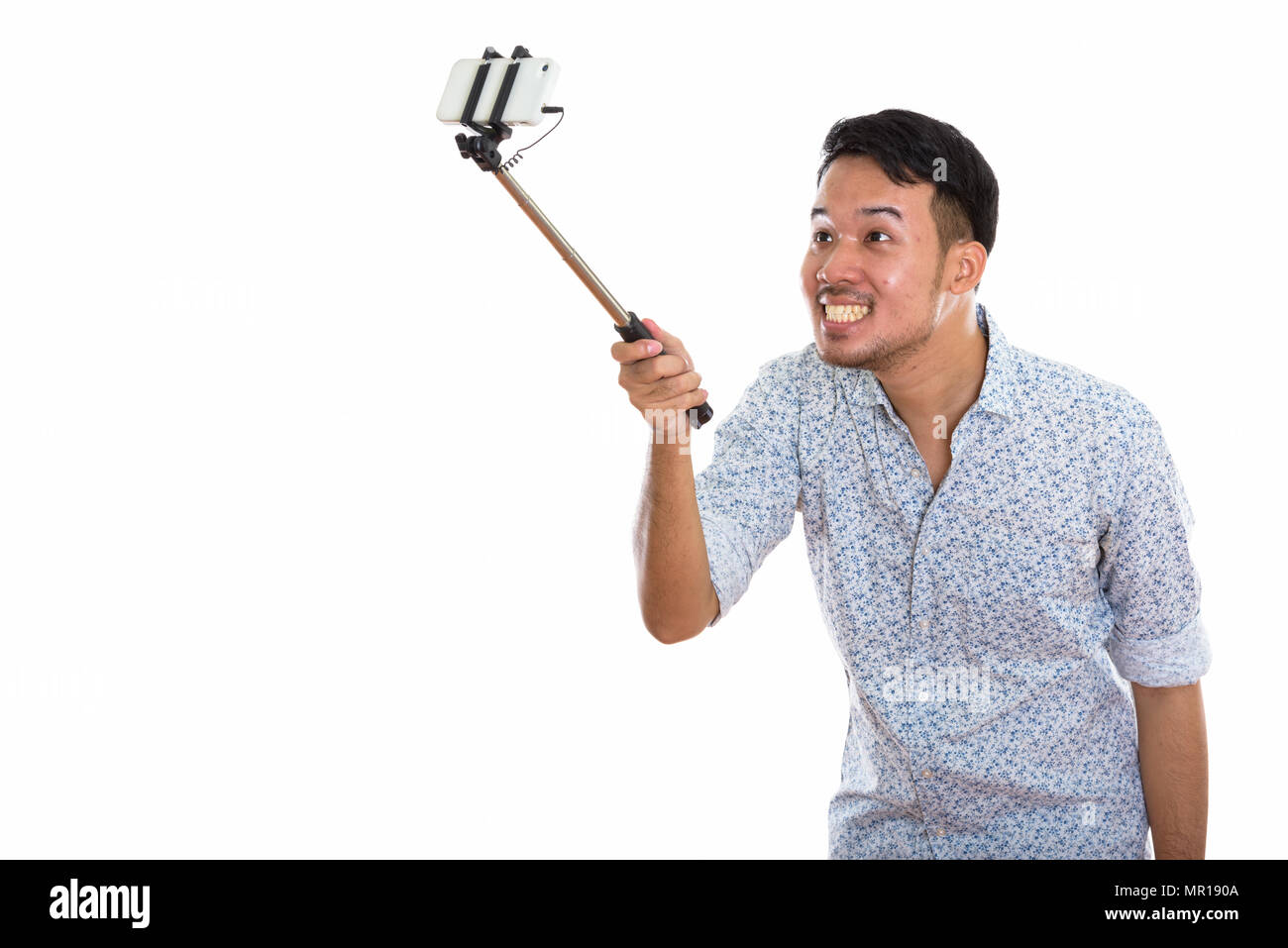 Giovani asiatici felice uomo sorridente e tenendo selfie foto con mob Foto Stock