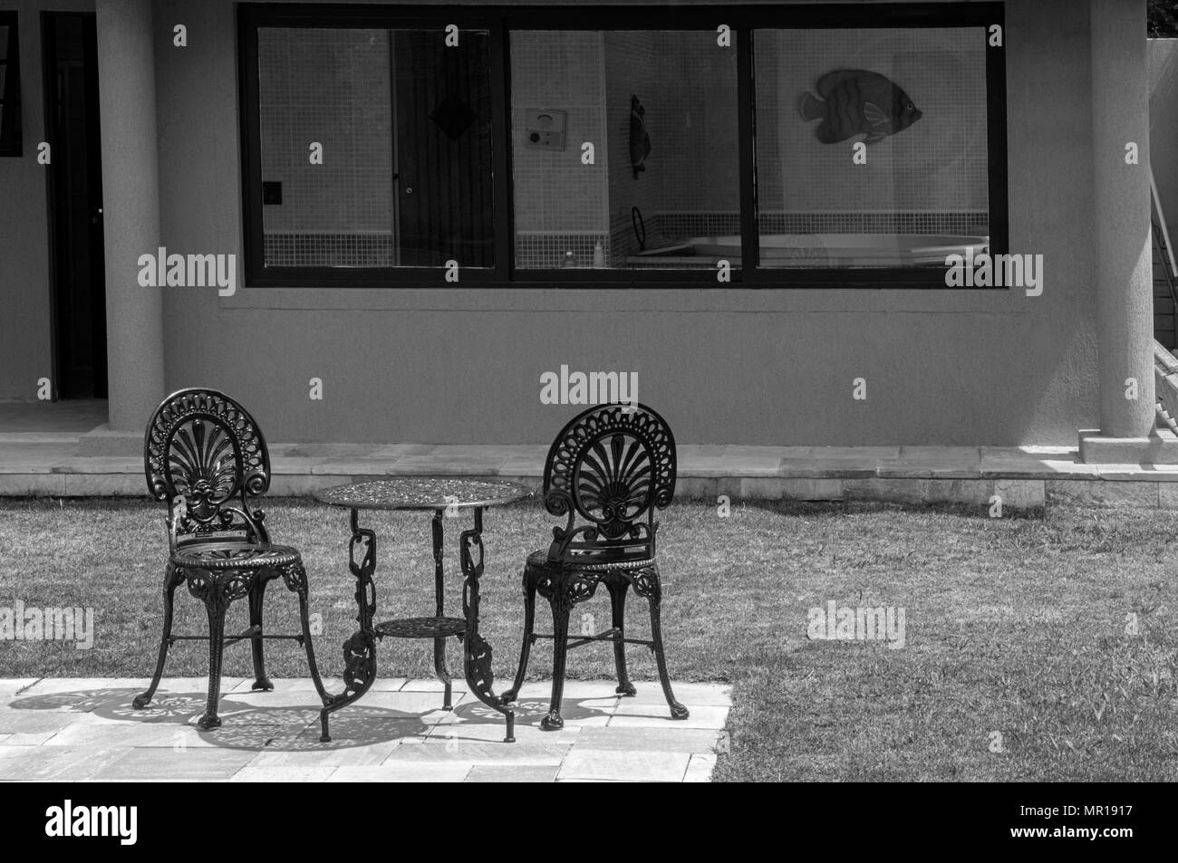 Giorno soleggiato giardino di erba tavola sedia relax jacuzzi dietro bianco nero Foto Stock