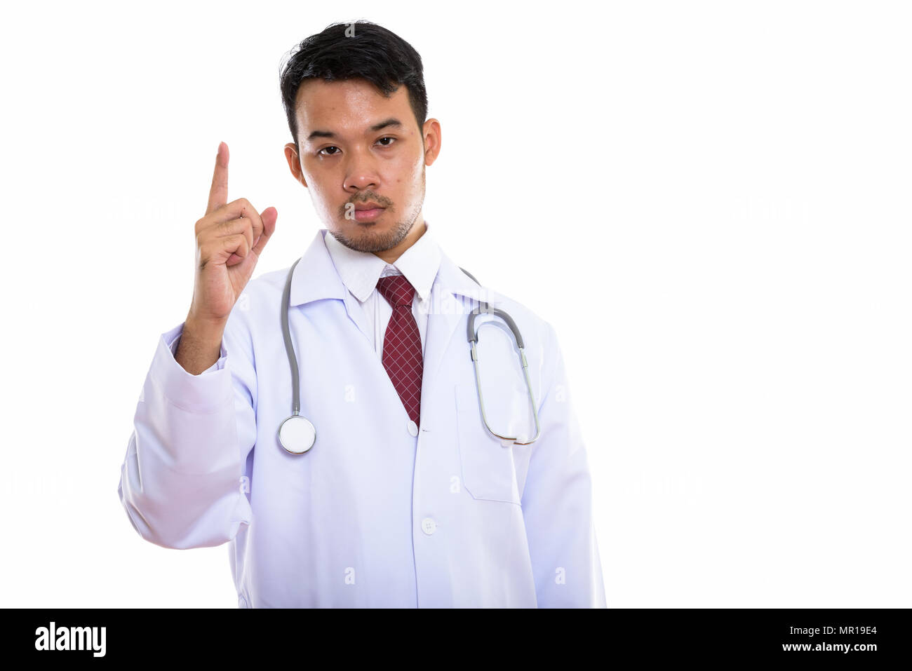 Studio shot del giovane uomo asiatico medico puntare il dito fino Foto Stock