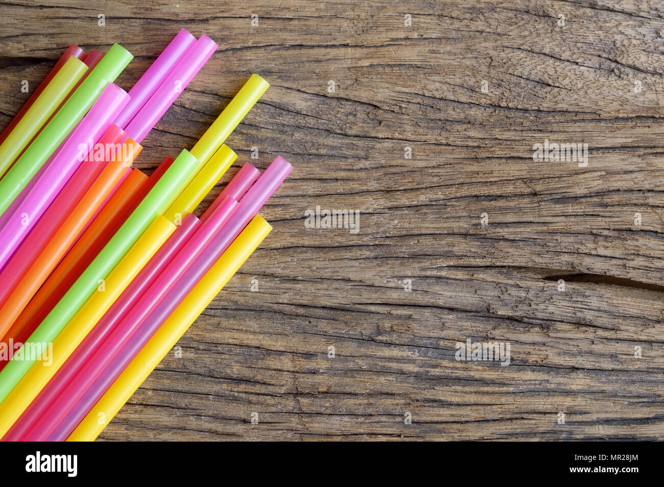 In plastica colorata cannuccia su sfondo di legno Foto Stock