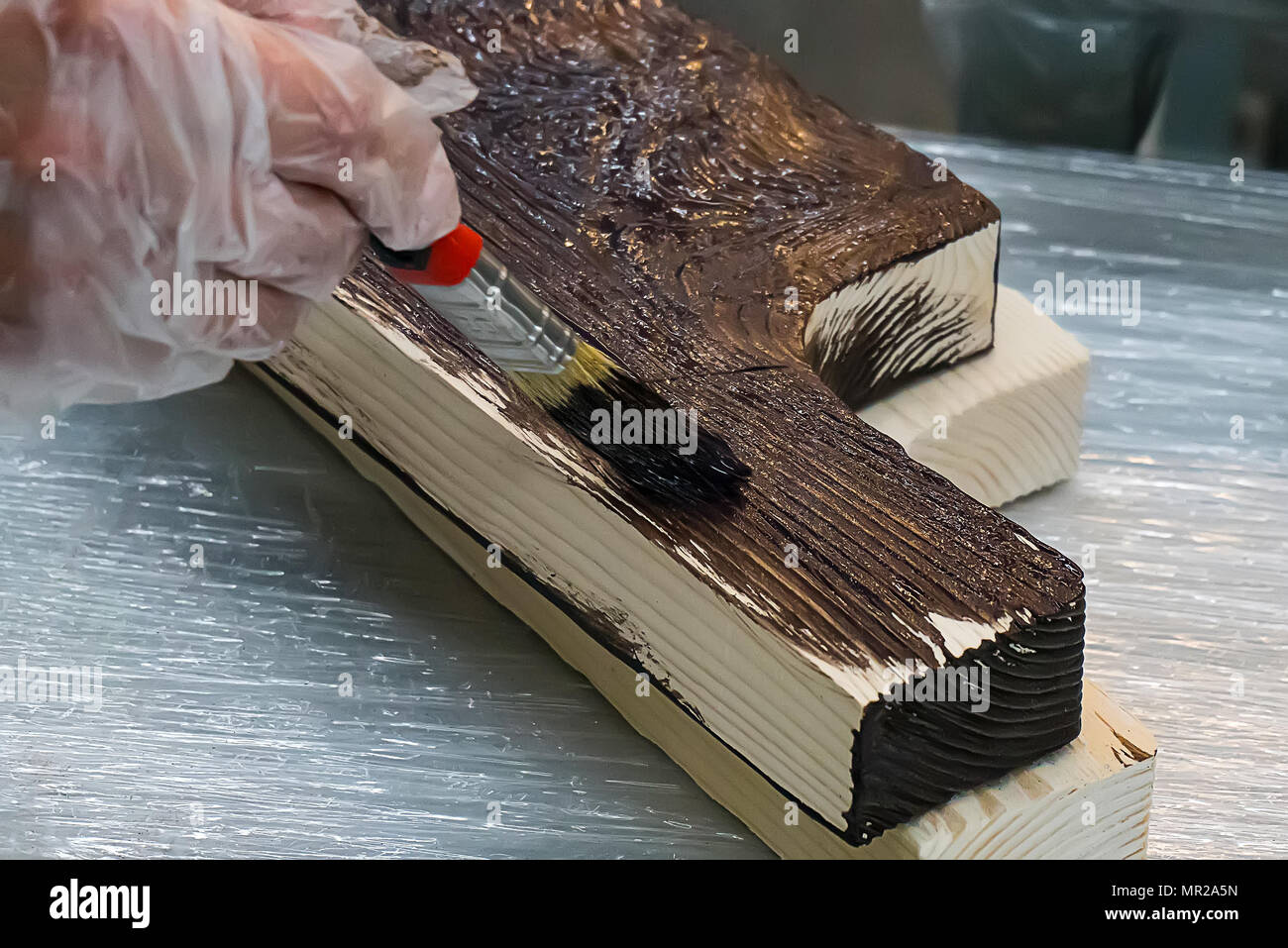 L'uomo dipinge una scatola di legno. costo copre il Lakme tagliere in legno con intaglio a mano. Realizzati a mano su legno. Laccato utensili da cucina. Il vecchio Russo Ucraino slavo di Foto Stock