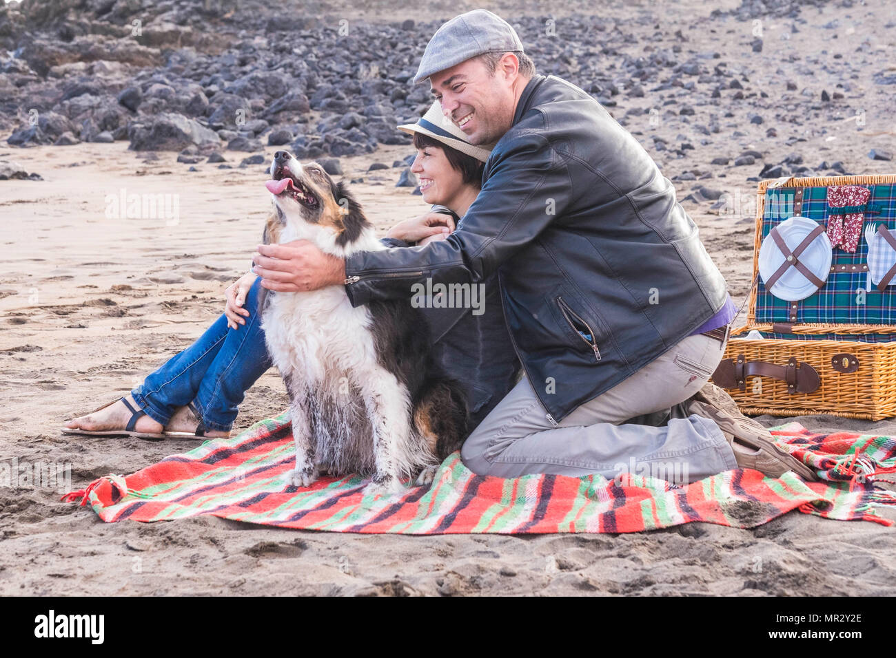 Libertà e tempo libero pic nic attività sulla spiaggia per una alternativa famiglia gruppo di amici due persona e un bel cane. Tutti hanno divertimento outdoor in Foto Stock