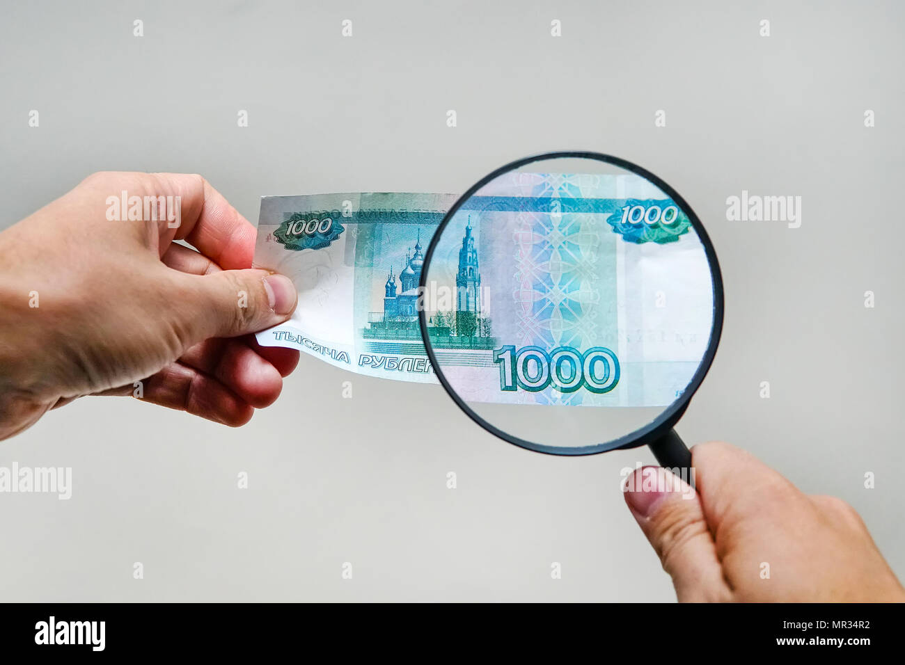 Expert con lente di ingrandimento controlli di denaro sospetti. cerca di filigrane sulla carta delle fatture false. lente di ingrandimento, Magnifier, lente di ingrandimento, magn Foto Stock