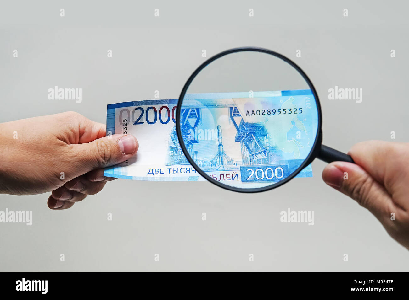 Expert con lente di ingrandimento controlli di denaro sospetti. cerca di filigrane sulla carta delle fatture false. lente di ingrandimento, Magnifier, lente di ingrandimento, magn Foto Stock