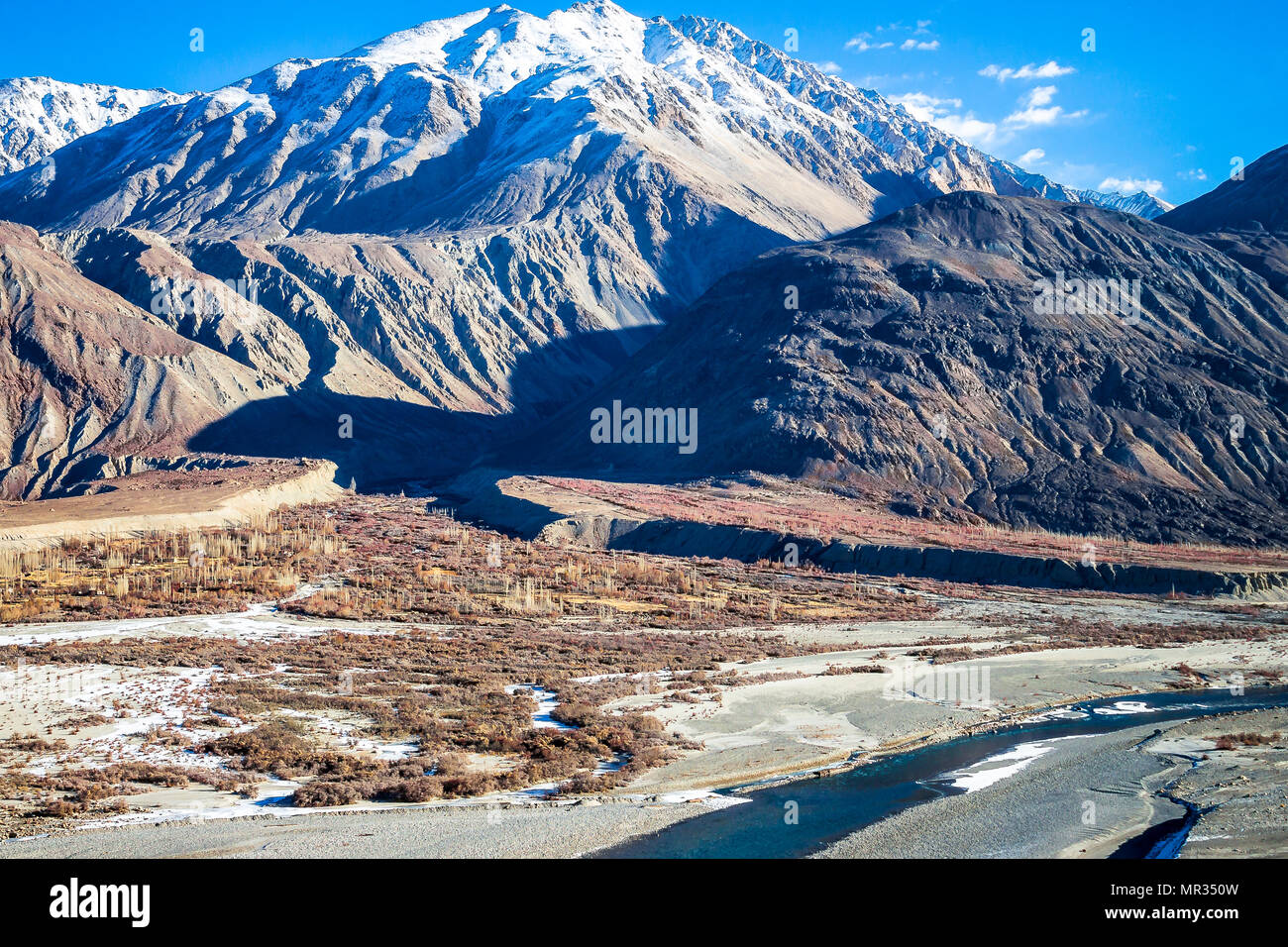 Alta montagna arida - Hanley fiume che scorre attraverso la roccia sharp montagne a ovest del Ladakh e gamma con appena un pizzico di neve a corona. Foto Stock