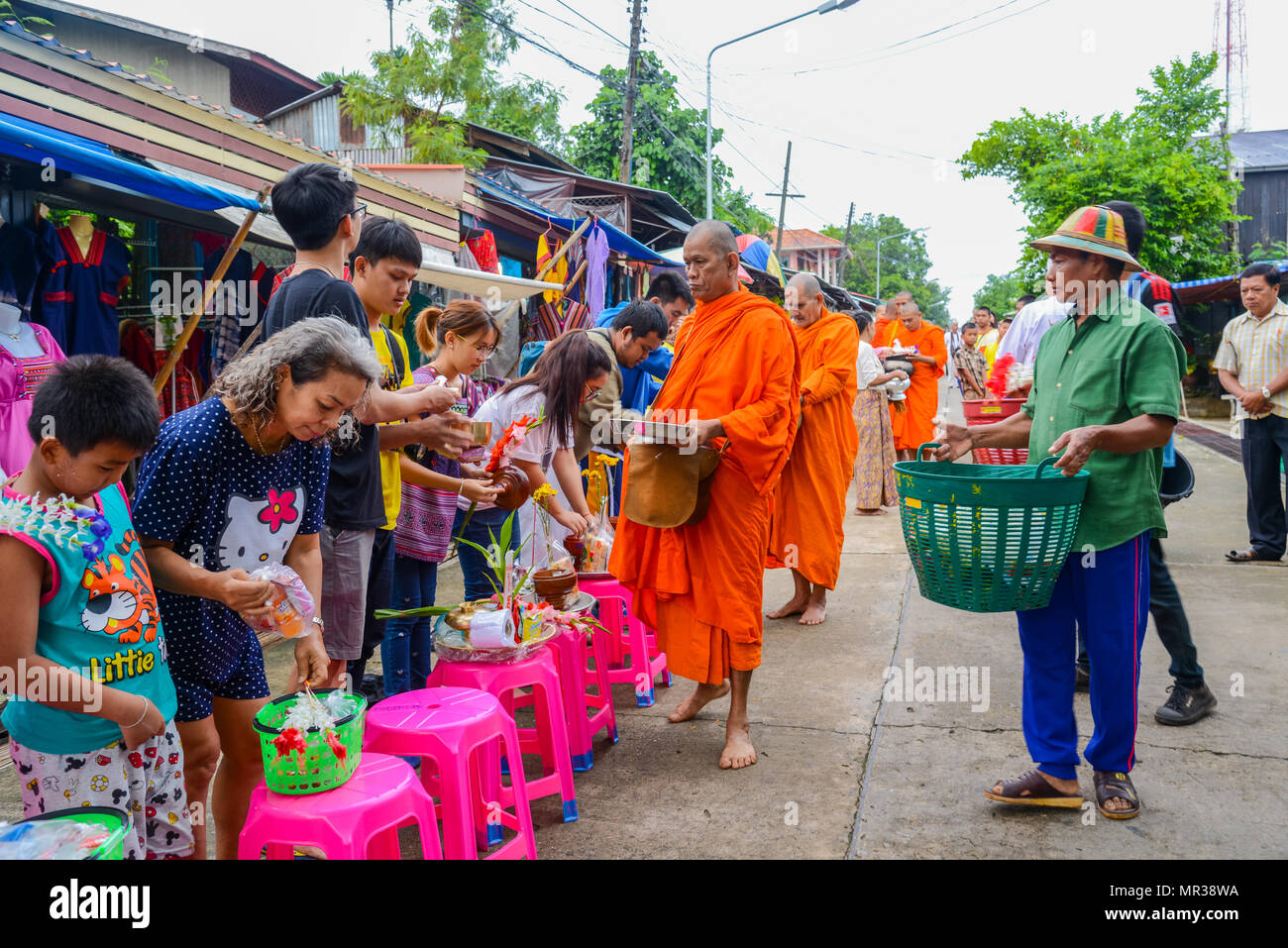 Kanchanaburi, Thailandia - Luglio 23, 2016: persone che offrono cibo e cose da un gruppo di monaci buddisti in mattinata sulla strada rurale in Kanchanaburi, Tailandia Foto Stock