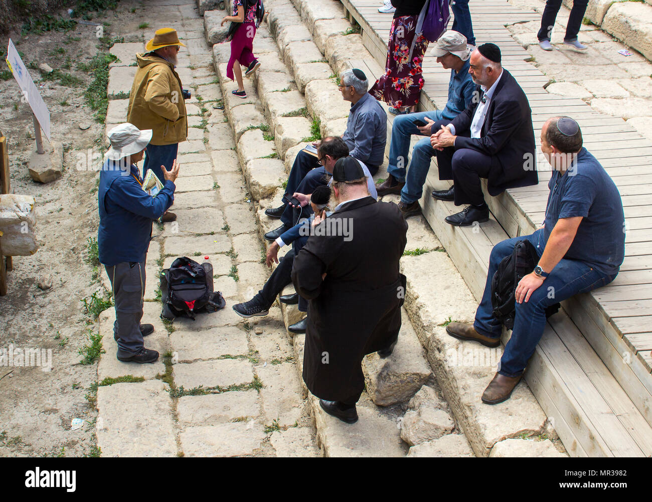 8 maggio 2018 un piccolo gruppo di ebrei uomini siedono sui gradini presso la piscina di Siloe a Gerusalemme ascoltando una guida turistica. Foto Stock