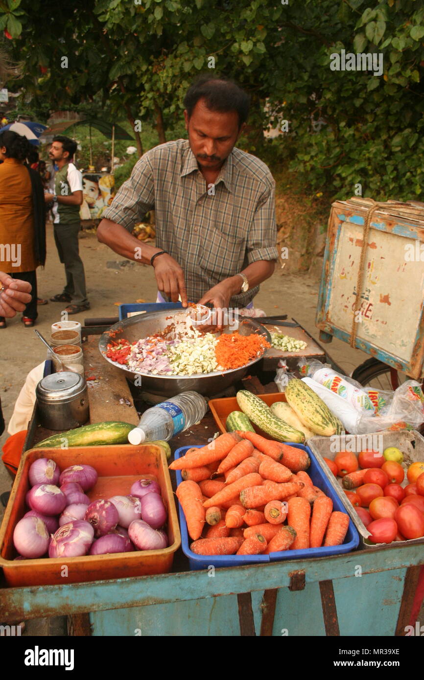 Uomo indiano preparare gustosi street food snack, Kovalam, India Foto Stock