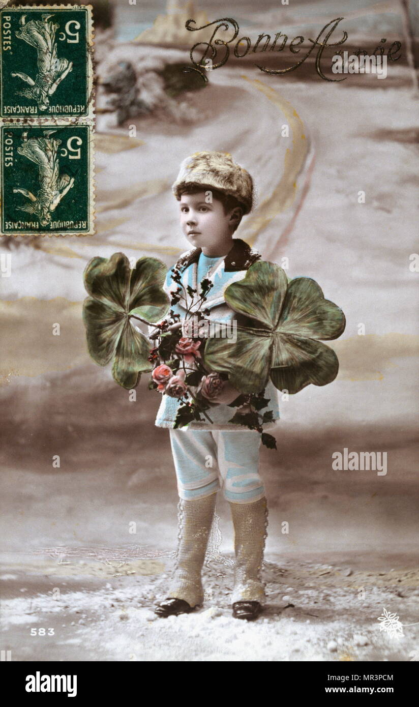 Il francese Felice Anno Nuovo, cartolina raffigurante un ragazzo con i fiori e un quattro foglia di trifoglio. 1900 Foto Stock
