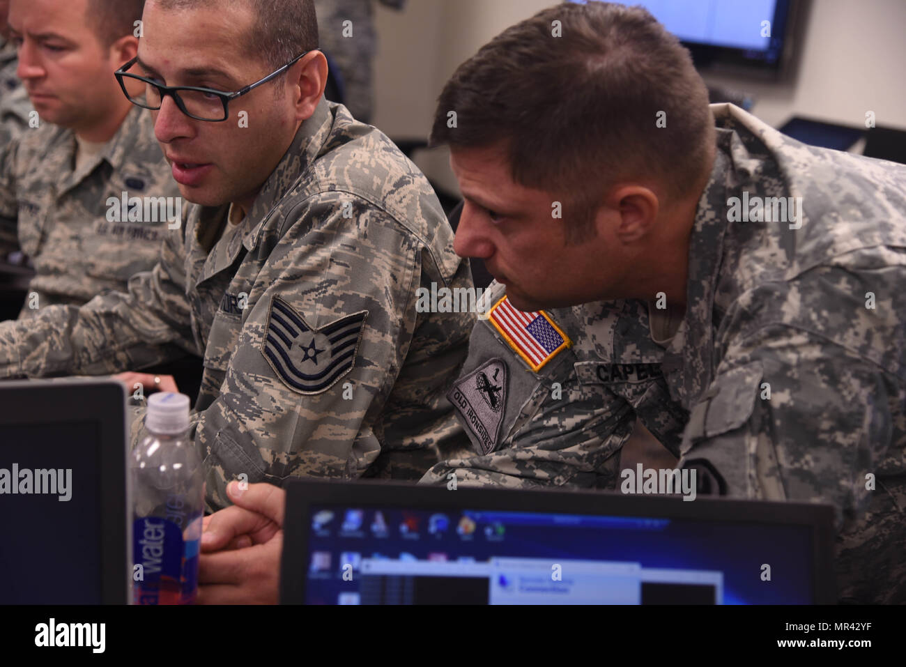 Louisiana National Guardsman Lt. Col. Henry Capello, esercitare il comandante della Cyber scudo 17, guarda come Louisiana Air National Guardsman e Cyber Defense Incident Response Team stati Tech Sgt. Joseph Mitchell 159Fighter Wing pratica la sua Cyber Defense abilità durante l'esercizio a Camp W.G. Williams in Bluffdale, Utah, Aprile 1, 2017. Circa 20 Louisiana soldati e aviatori sono corsi di formazione per mantenere e migliorare la loro cyber resilienza con oltre 850 altre guardie da oltre 42 Stati e territori nonché dell Ufficio federale delle indagini e il dipartimento di Hom Foto Stock