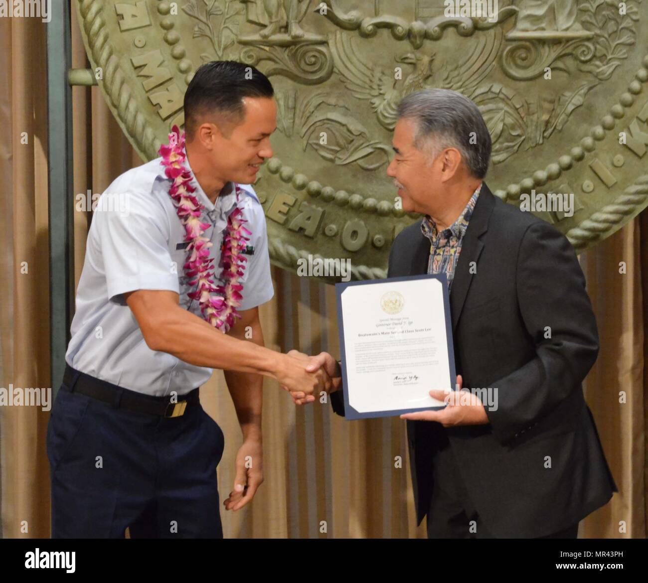 Petty Officer 2a classe Scott Lee, un boatswain compagno di stanza presso Stazione della Guardia Costiera di Honolulu, è stato riconosciuto per il suo eccezionale servizio alla comunità dalla Hawaii governatore dello Stato David Y. Ige a Hawaii State Capitol, 5 maggio 2017. I militari del Consiglio Affari Esteri della Camera di Commercio di Hawaii uniti governatore Ige in un annuncio cerimonia può designare come apprezzamento militare al mese e per onorare i membri del servizio da tutti e cinque i rami delle forze armate per il loro servizio alla comunità dei contributi. (U.S. Coast Guard foto di Sottufficiali di 2a classe di Melissa E. McKenzie/rilasciato) Foto Stock