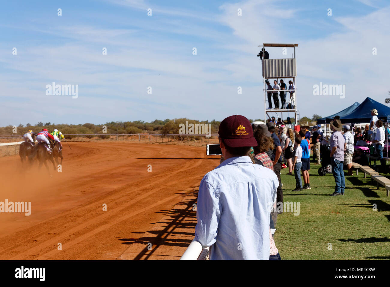 Uomo che indossa Parlamento australiano Cap catturare un cavallo di razza con telefono cellulare, Mt magnete, Eastern Goldfields, Australia occidentale Foto Stock