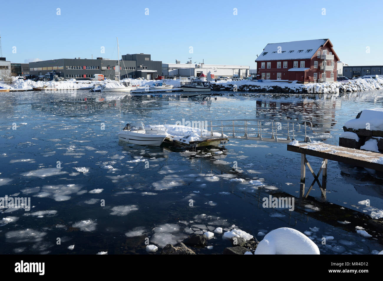 Norvegia Lofoten, Svolvaer, parzialmente congelati del porto interno con ghiaccio galleggiante e barche da diporto. Foto Stock