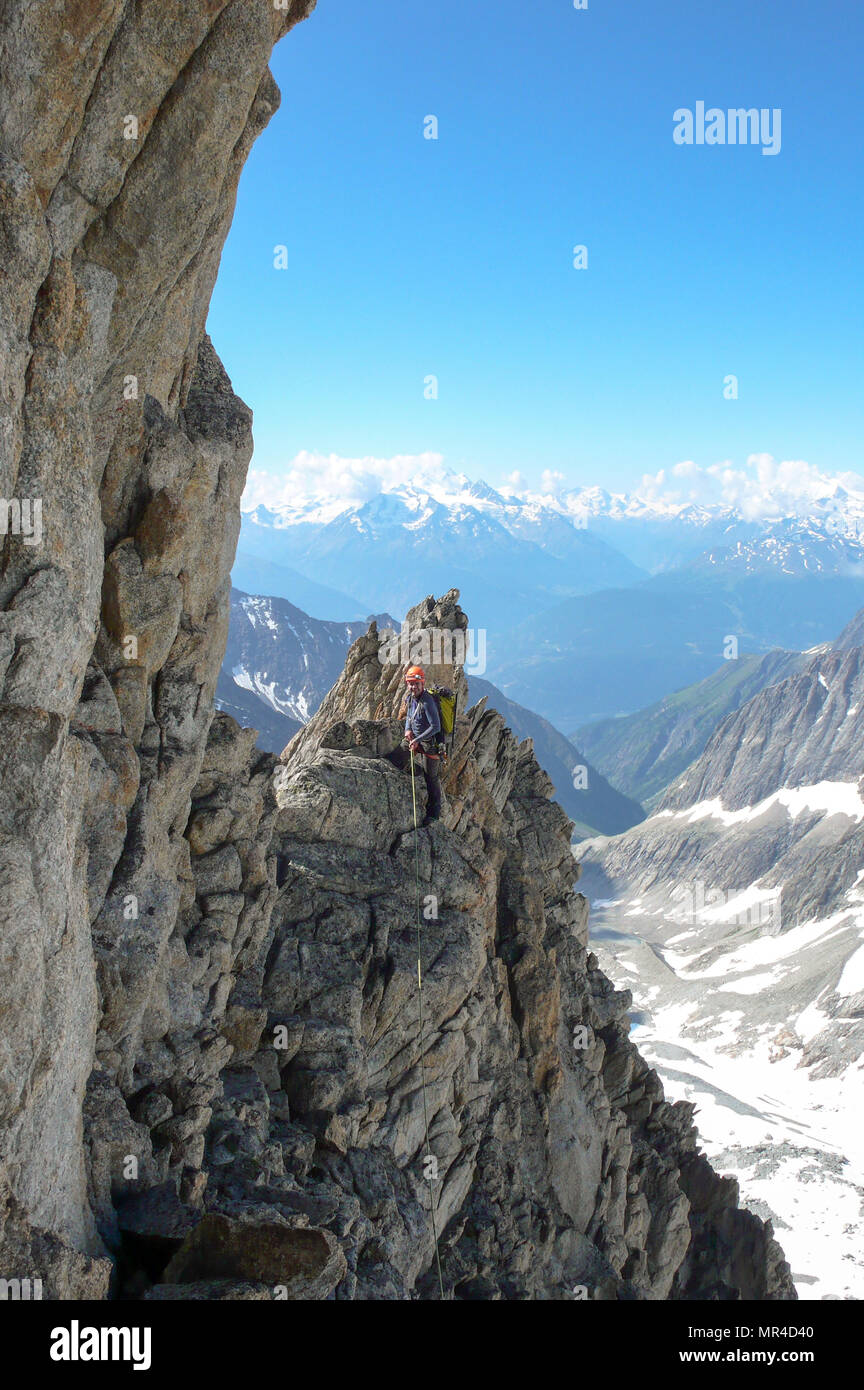 Maschio guida di montagna portano la scalata su esposta una cresta di granito nelle Alpi Foto Stock
