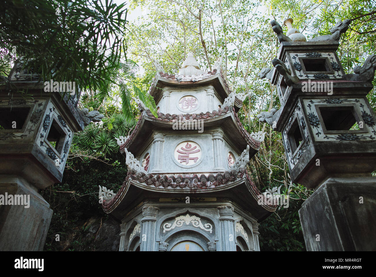 Basso angolo vista di antica tradizione tempio orientale tra piante verdi, Da Nang, Vietnam Foto Stock