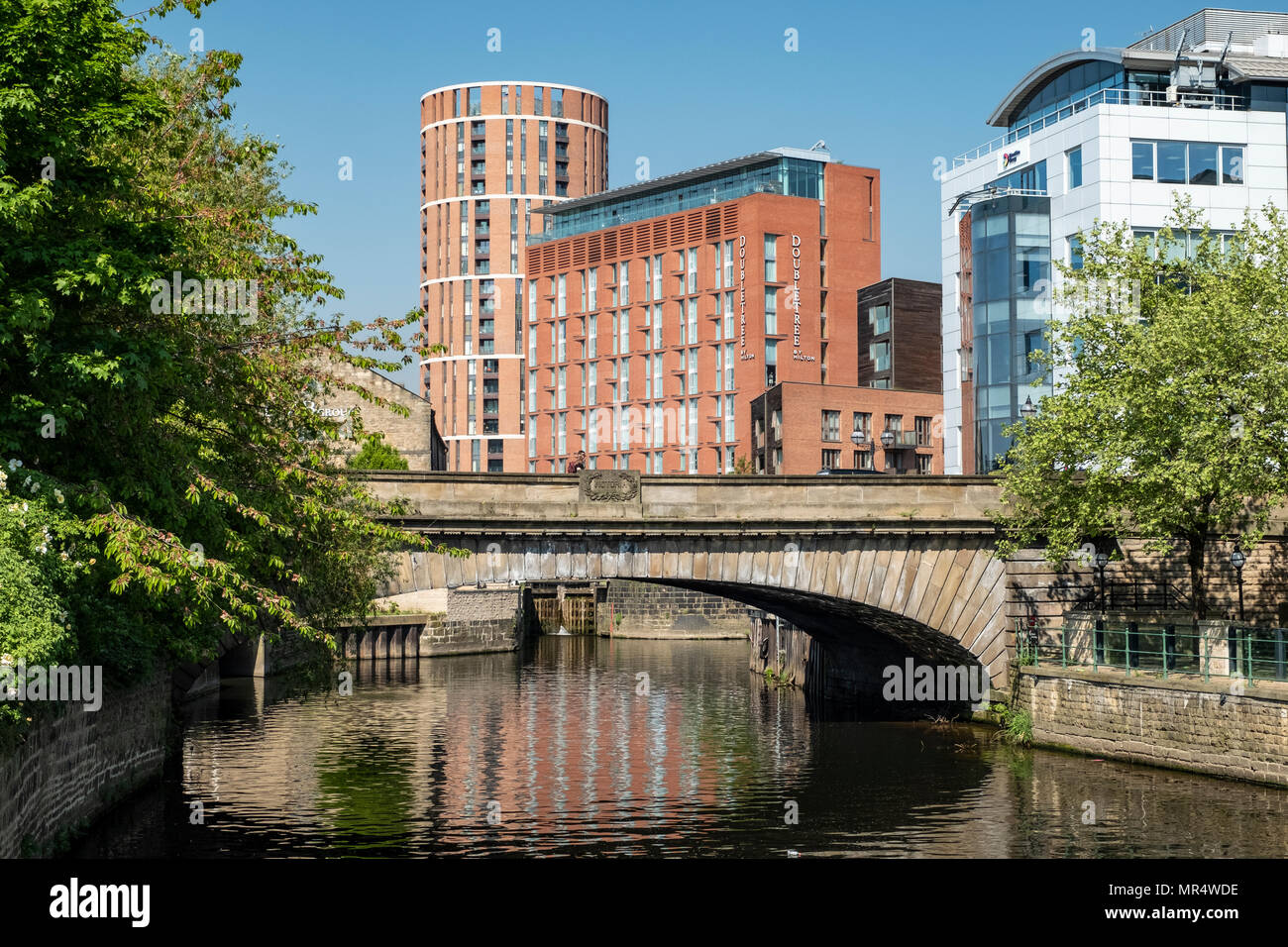 Vecchi edifici industriali e moderni appartamenti sul molo ristrutturato dal fiume Aire in zona lungomare, Leeds, West Yorkshire, Inghilterra, Regno Unito. Foto Stock