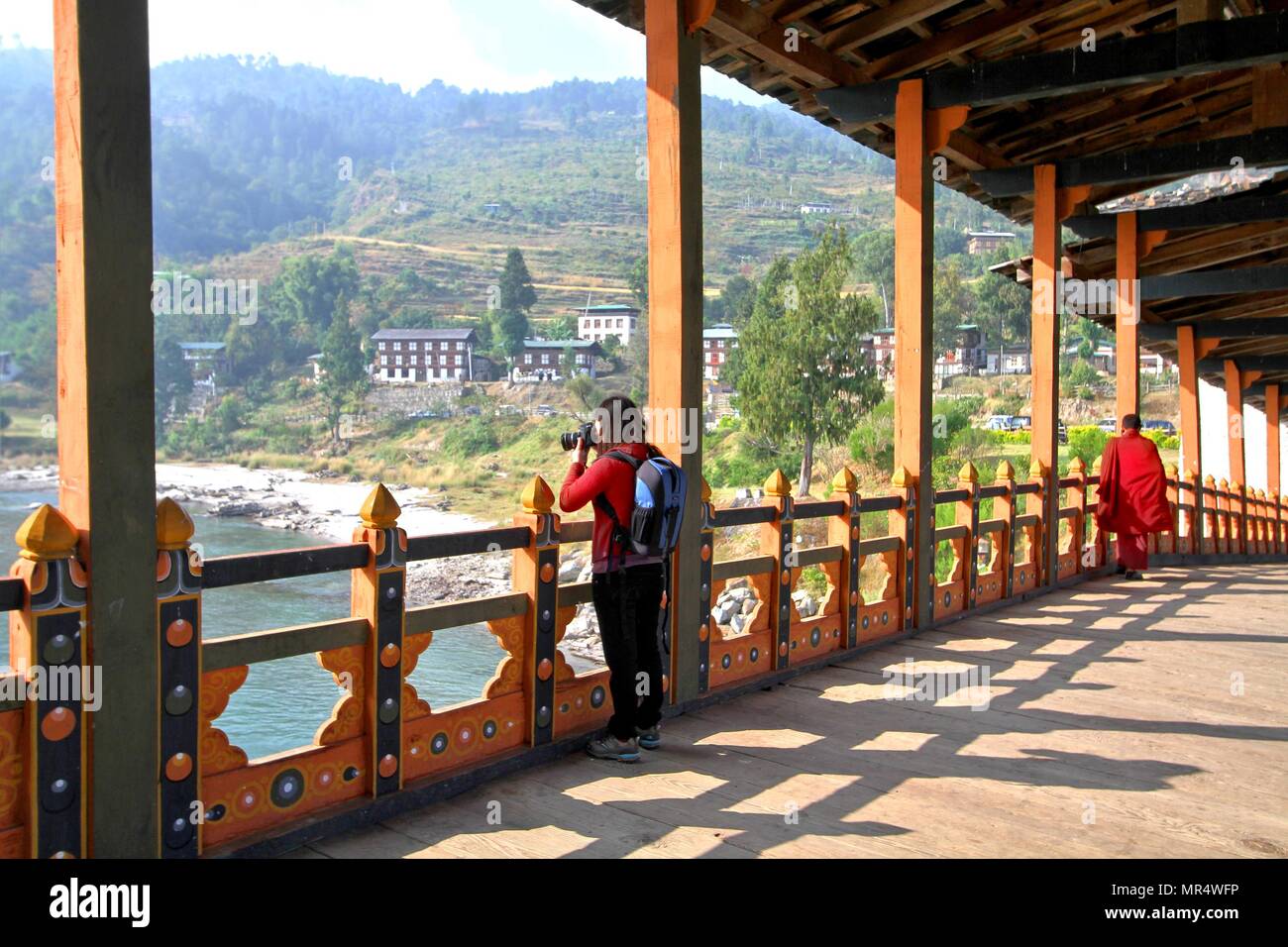 Turista femminile prendendo ancora a PUNA MOCCHU BAZAM : antico ponte in legno a Punakha Dzong monastero o Pungthang Dewachen Phodrang Bhutan Foto Stock