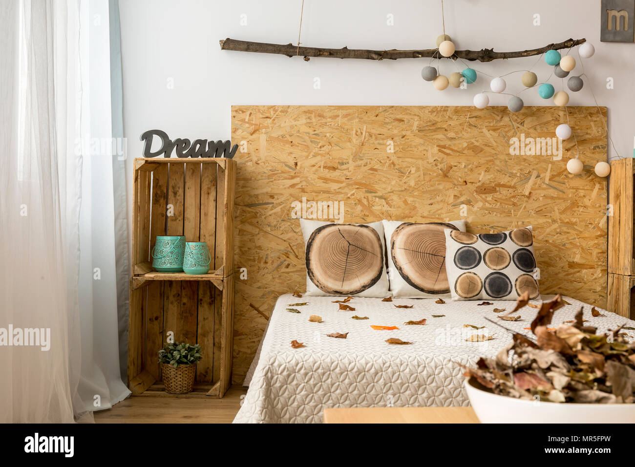 Accogliente camera da letto in tonalità autunnali con letto doppio e scatole di legno come mobili per il FAI DA TE Foto Stock