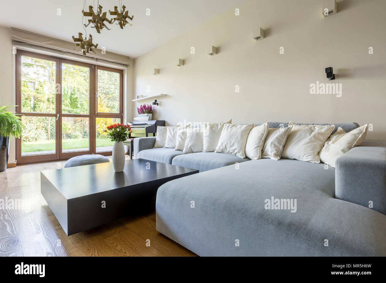 Spazioso soggiorno interno con grande divano Foto Stock