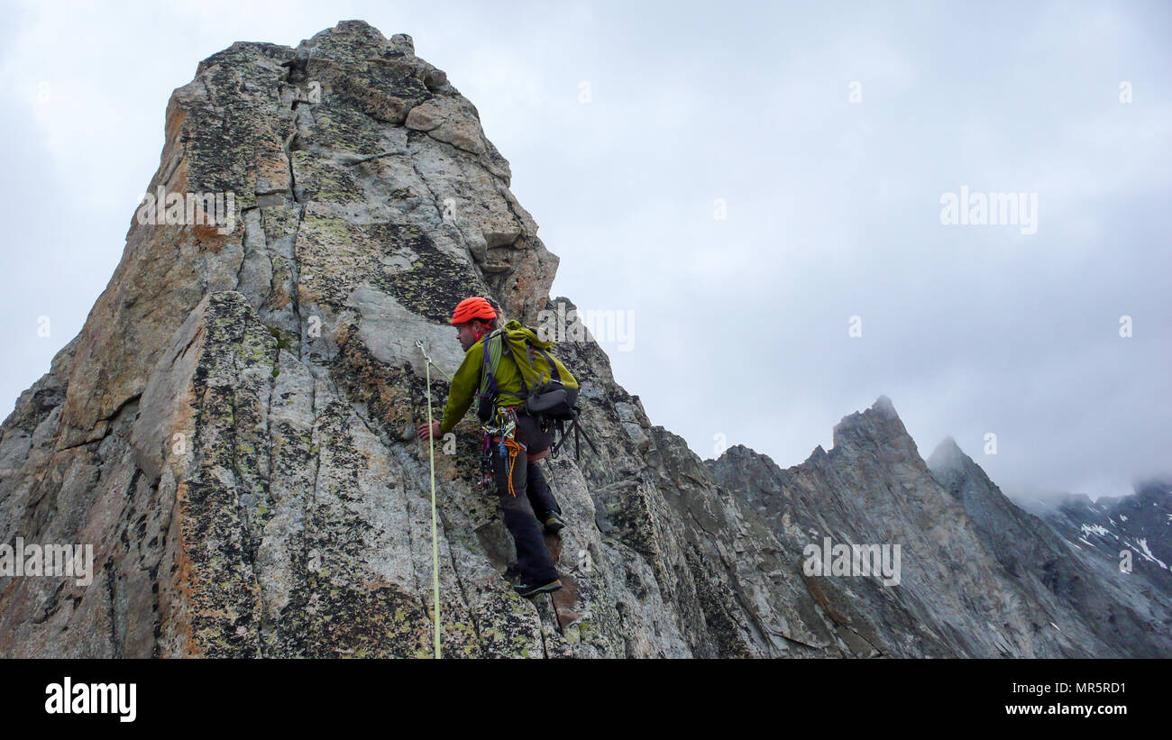 Maschio guida di montagna portano la scalata su esposta una cresta di granito nelle Alpi Foto Stock