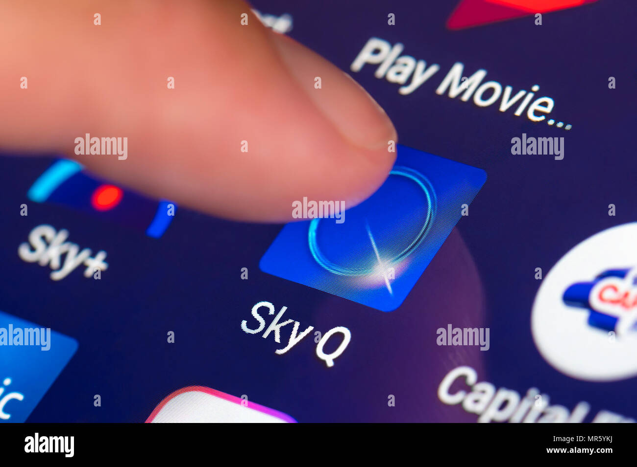 Dito che preme un cielo Q Icona app su un dispositivo mobile o tablet. Sky TV su un tablet nel Regno Unito. Foto Stock