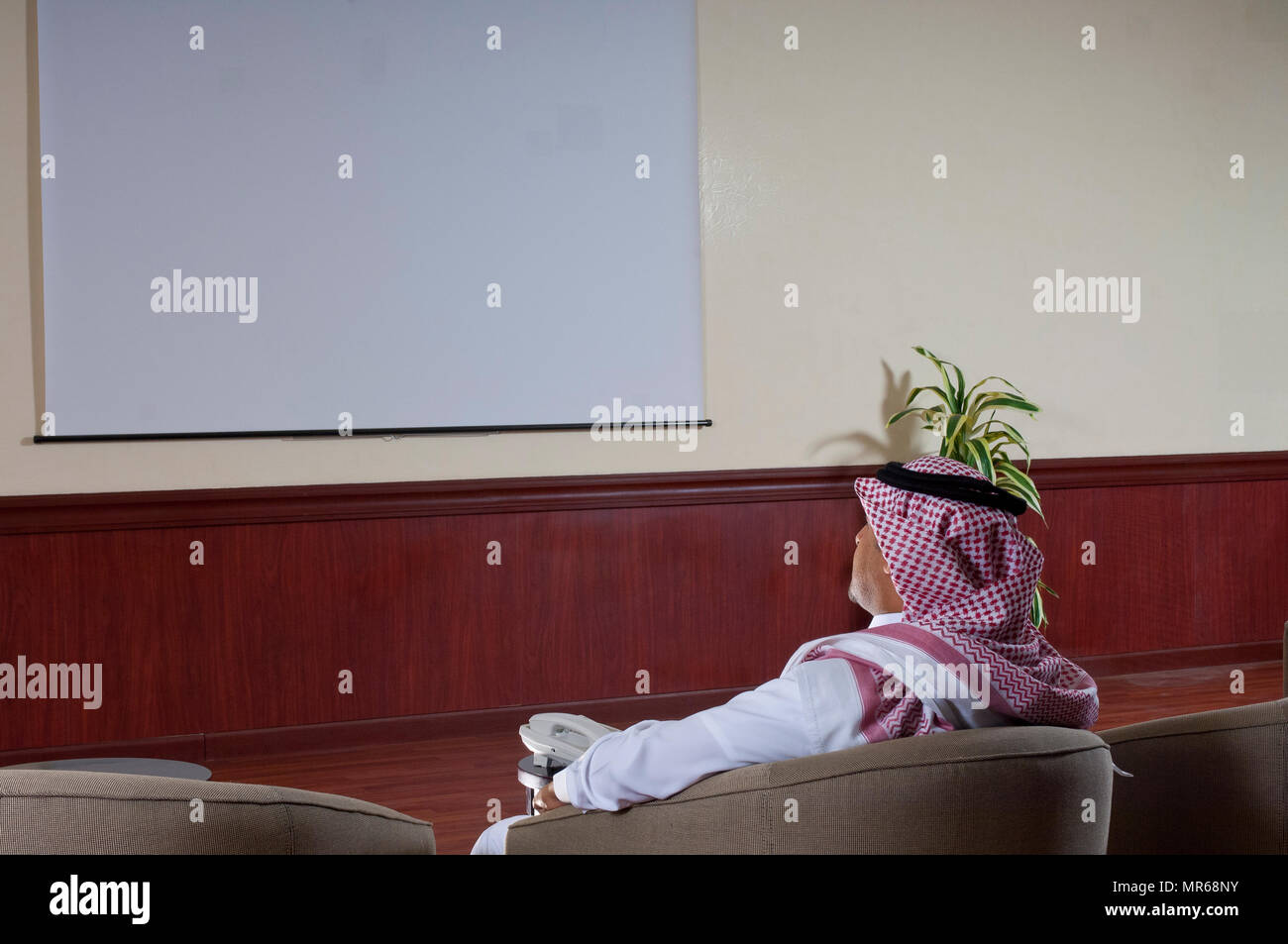 Arabo Saudita imprenditore guardare grande schermo di proiezione Foto Stock