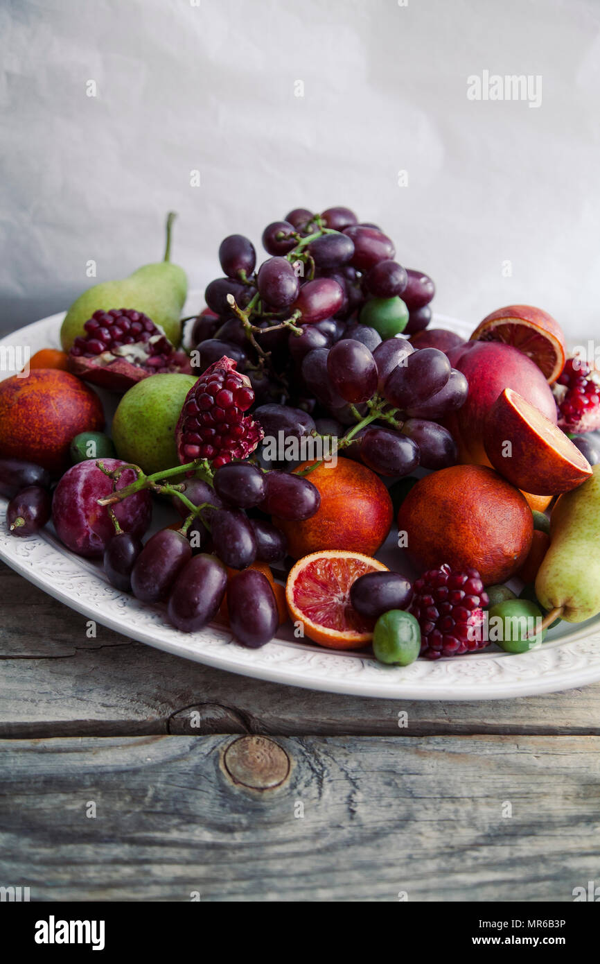 Buon piatto di frutta fresca con melograno, uva e pere Foto Stock