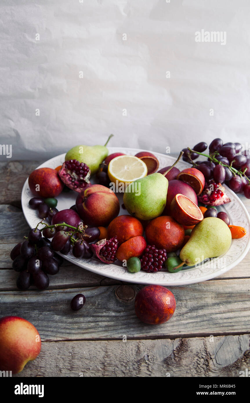 Buon piatto di frutta fresca con melograno, uva e pere Foto Stock
