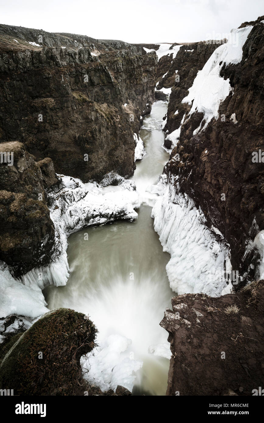 Parzialmente cascate ghiacciate in un canyon, monocromatica, Kolugljúfur gorge, regione nord-occidentale, Islanda Foto Stock