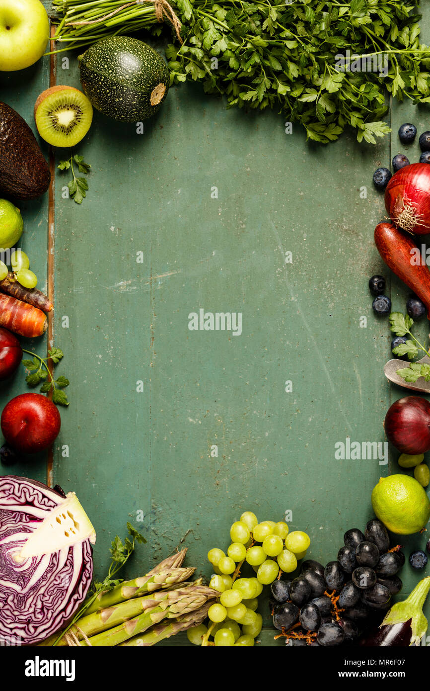 Assortimento di materie frutta e verdura biologiche: Melanzane, cipolle, bacche, carote, uva, cavolo, avocado, prugne su sfondo rustico, glutine f Foto Stock