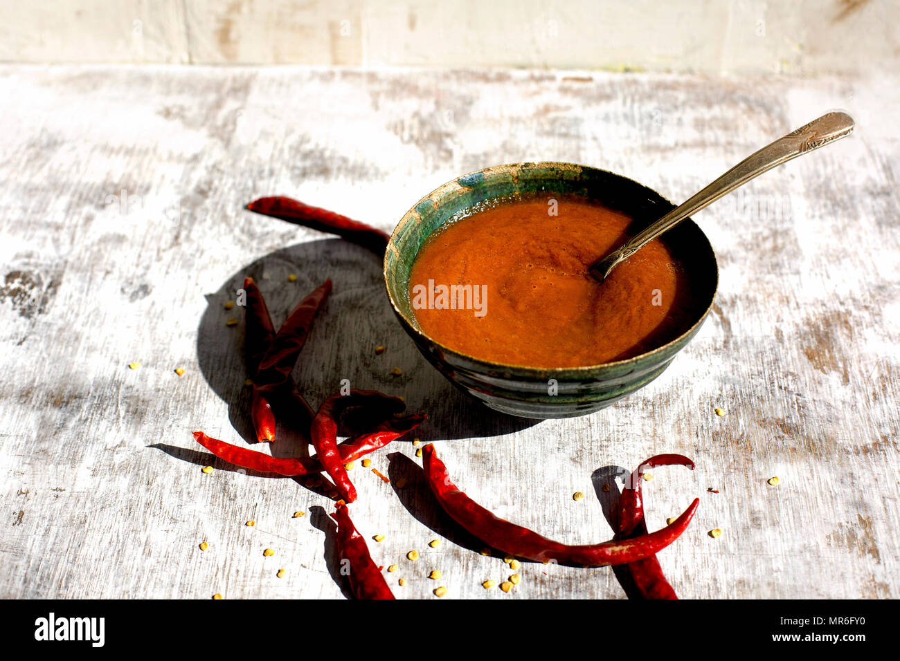 Ciotola di salsa calda con Arbol Peperoncino. Fotografato su un rustico sfondo bianco. Foto Stock