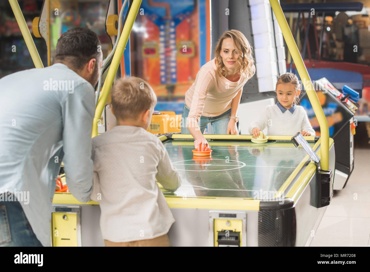 La famiglia felice giocare air hockey insieme in un centro di intrattenimento Foto Stock