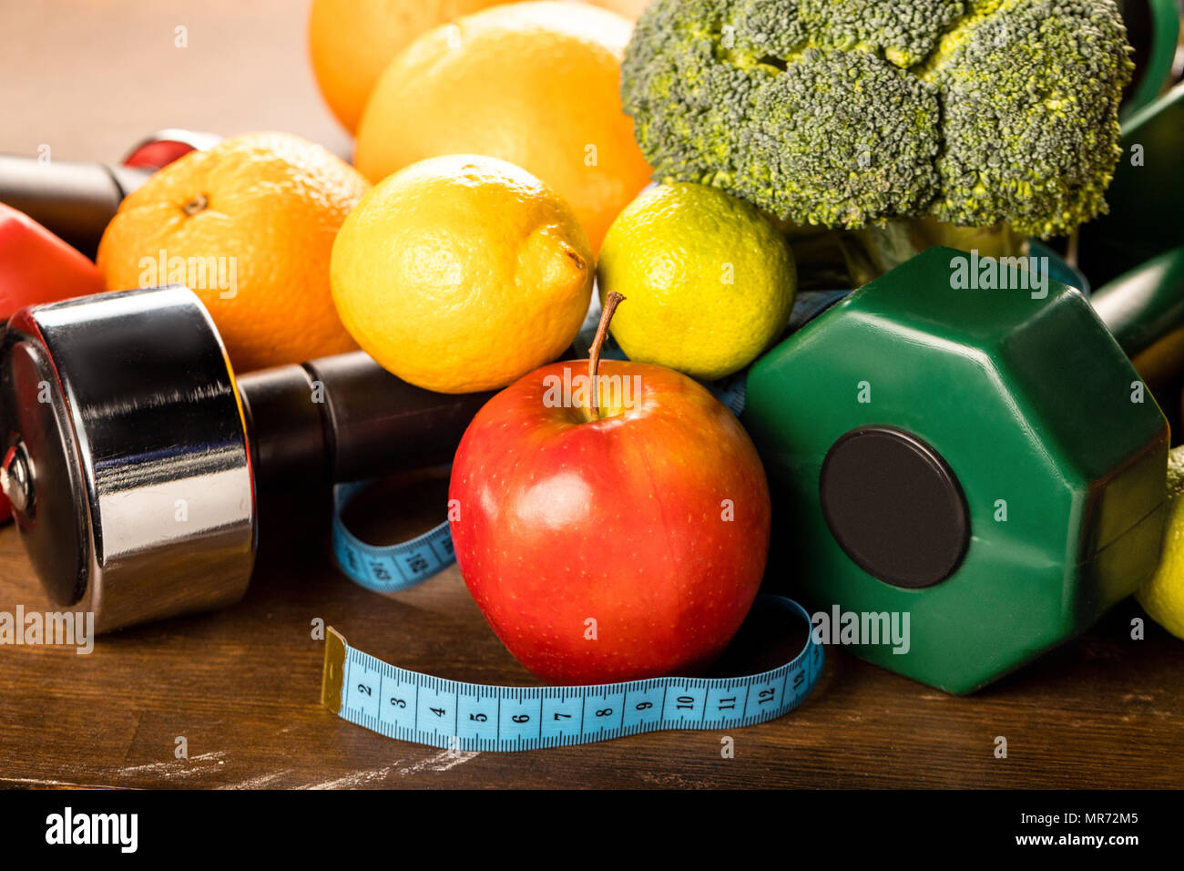 Vista ravvicinata del cibo sano, nastro di misurazione e manubri, vita sana nozione Foto Stock