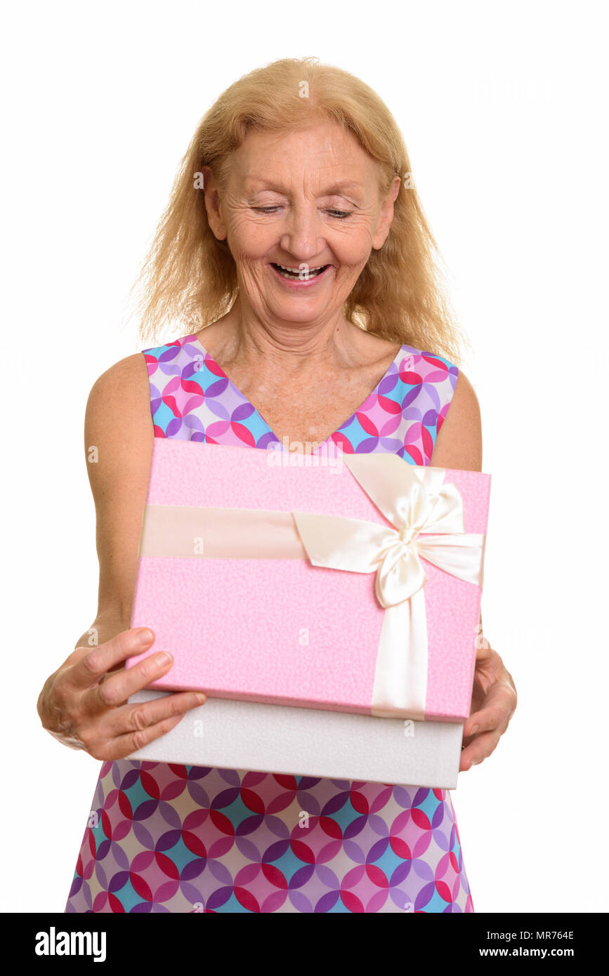Studio shot di felice senior donna sorridente durante l'apertura della confezione regalo Foto Stock