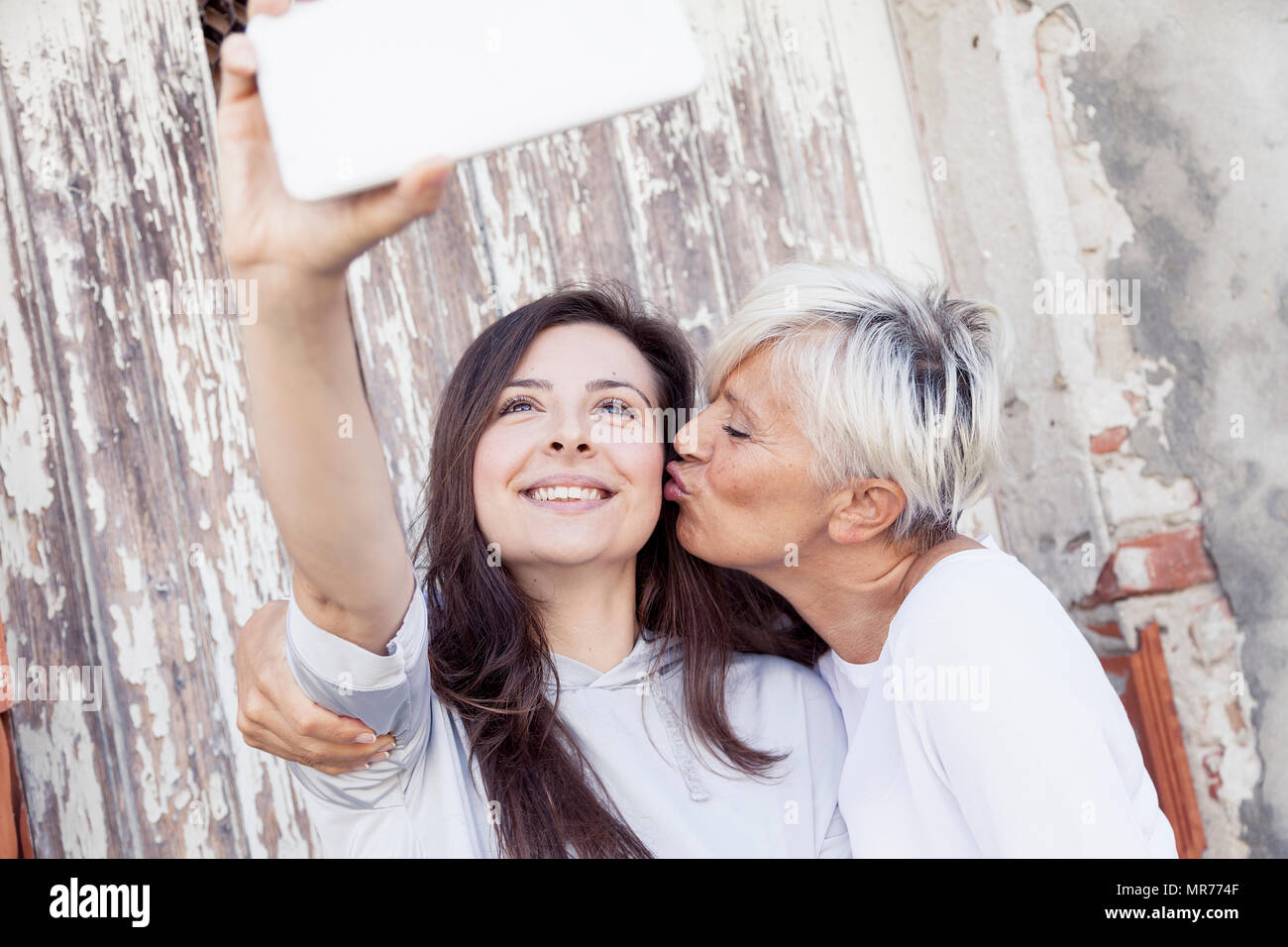 Madre e figlia adulta prendere un selfie all'aperto Foto Stock