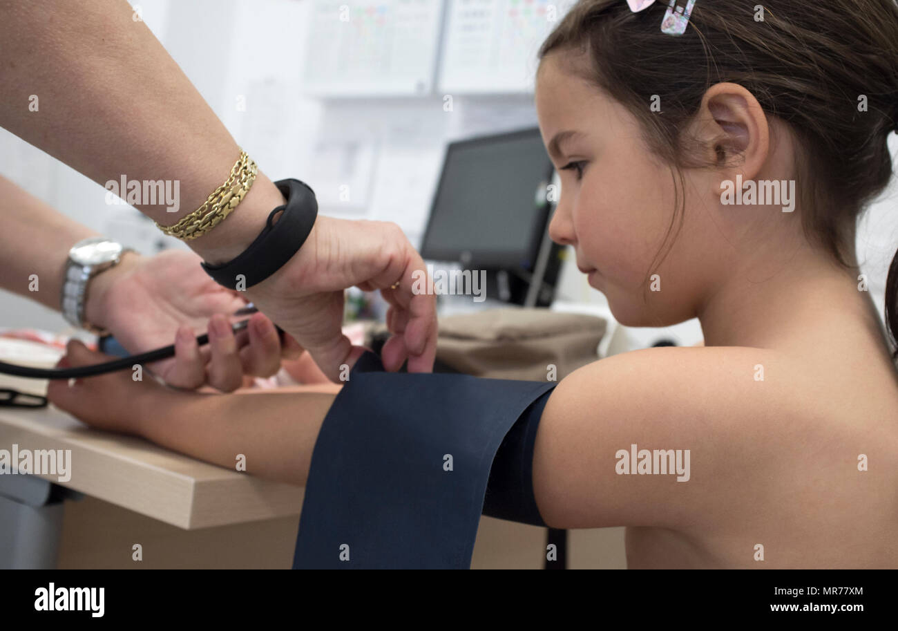 Bambina essendo dando del test della pressione del sangue medico. Periodico riesame pediatrico concept Foto Stock