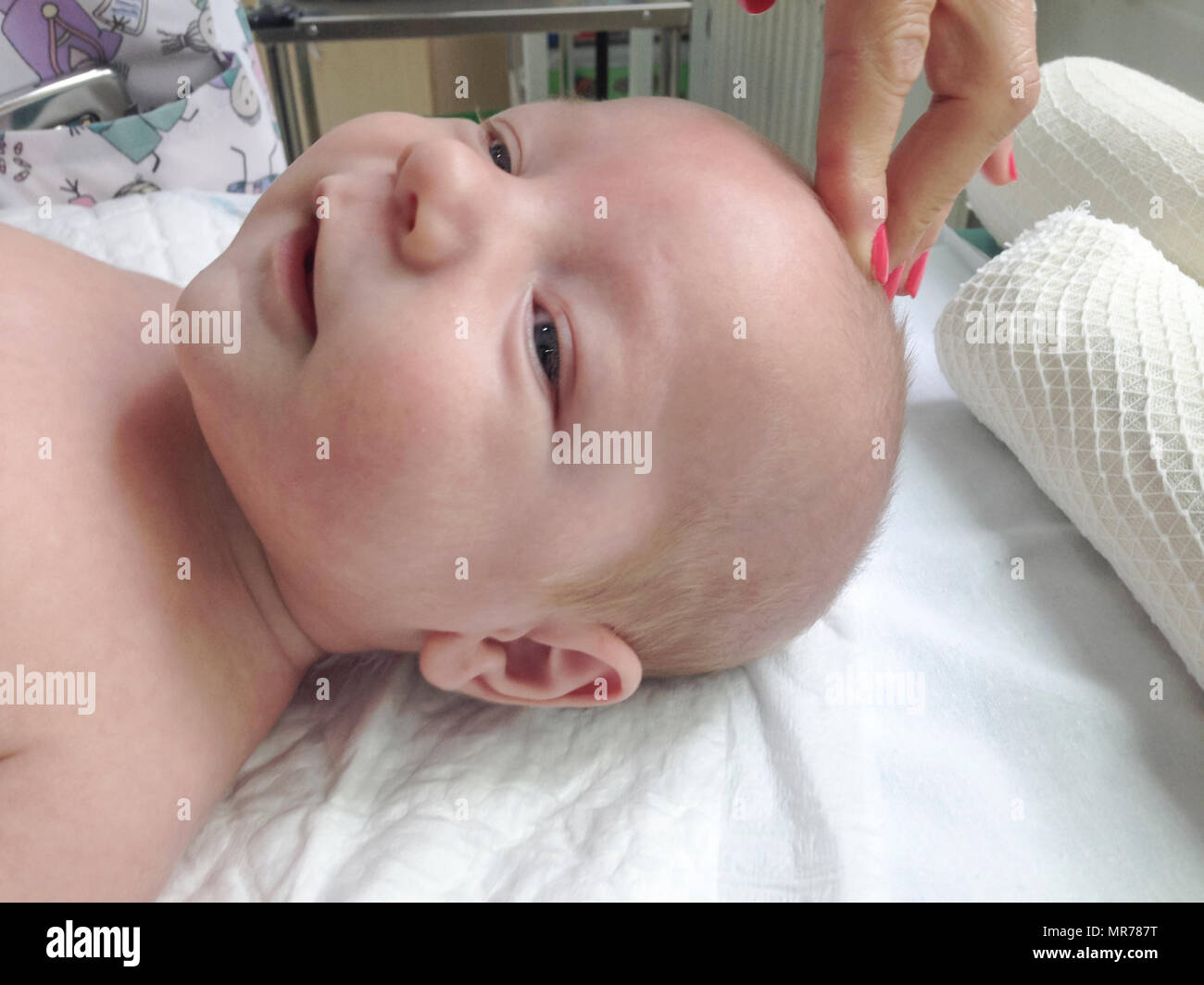 Pediatra esaminando le fontanelle di sorridere 3 mesi baby boy Foto Stock