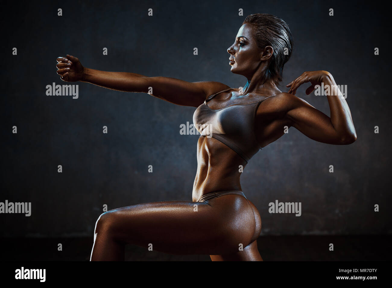 Sport forte donna sulla parete dello sfondo. Scuri colori drammatici. Foto Stock