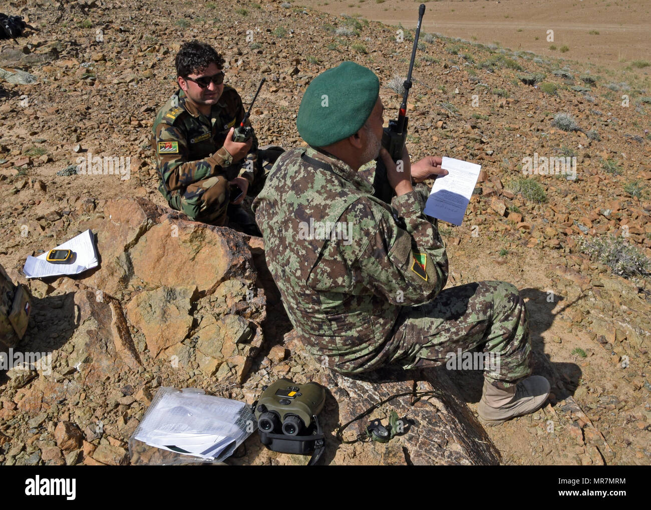 Afghan Air Force membri comunica sul terreno con una A-29 Super Tucano pilota su comunicazioni radio vicino a provincia di Logar, Afghanistan, 21 maggio 2017. Treno, consulenza, assistenza Command-Air (TAAC-aria) consulenti, terrà un live-formazione antincendio esercizio per una classe di afgane Tactical Air coordinatori. Prima dell'esercizio, i consulenti da TAAC-aria effettuato tre settimane di formazione in aula. Il live fire esercizio è parte di una valutazione pratica prima di Afghan Air Force Il personale può laurearsi come ATACs. (U.S. Air Force foto da Tech. Sgt. Veronica Pierce) Foto Stock