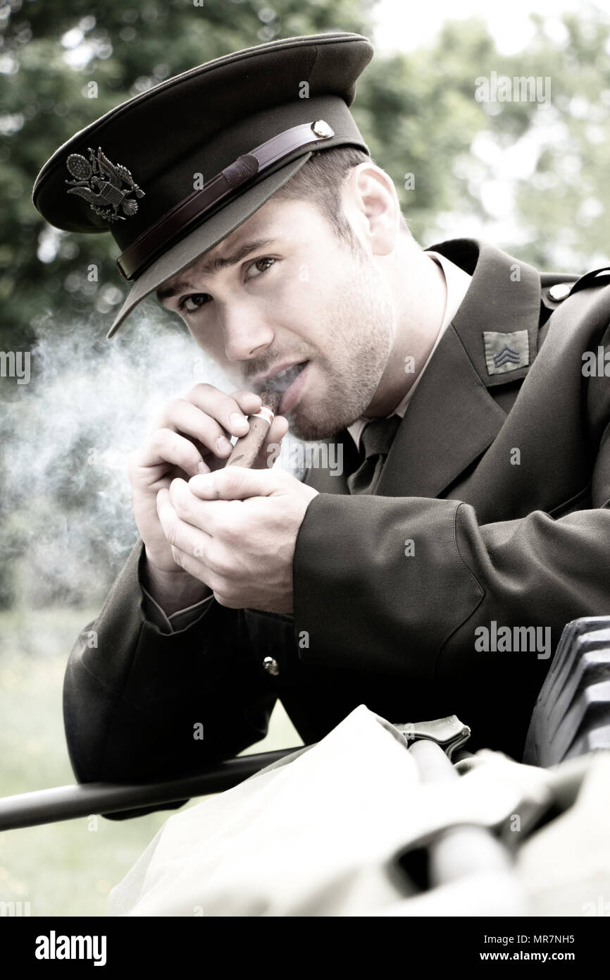 Vintage americano bello uomo, soldato, SGT nella guerra mondiale 2 officer uniforme  si rilassa e fuma un sigaro accanto a Willy Jeep con campagna britannica un  Foto stock - Alamy