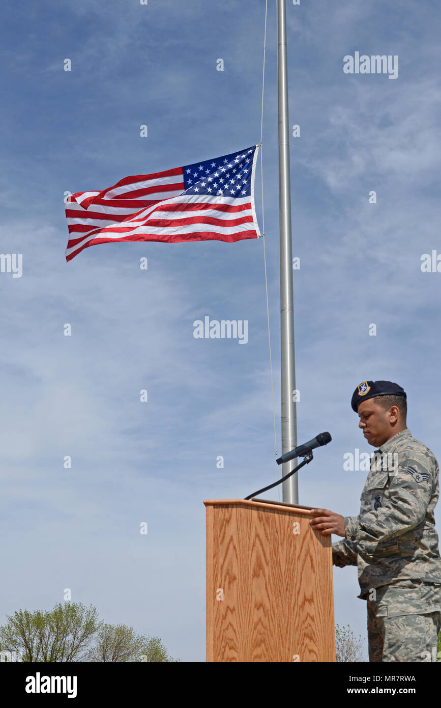 Senior Airman Eduardo Virgilio, 5a forze di sicurezza Squadron stati, recita caduti degli ufficiali di nomi nel corso di una polizia nazionale settimana di ritiro a cerimonia Minot Air Force Base, N.D., 19 maggio 2017. Un ritiro cerimonia è la quotidiana pratica militare di abbassare la bandiera. (U.S. Air Force foto/Airman 1. Classe Austin M. Thomas) Foto Stock