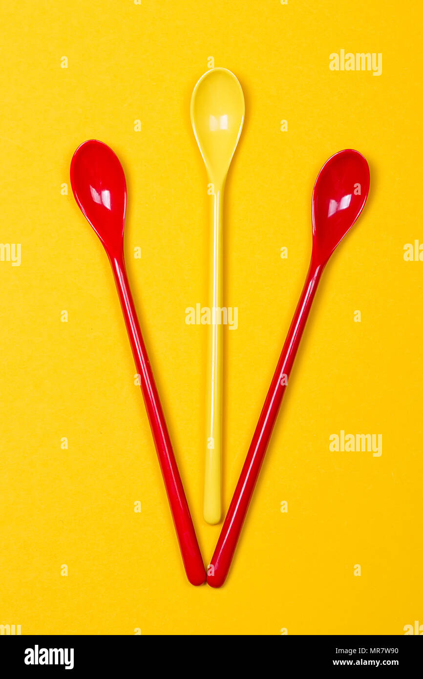 Set di multi-colore di cucchiaini lunghi su sfondo giallo Foto stock - Alamy