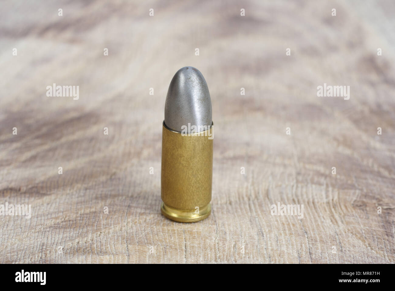 Il calibro 9mm cartuccia su sfondo di legno Foto Stock