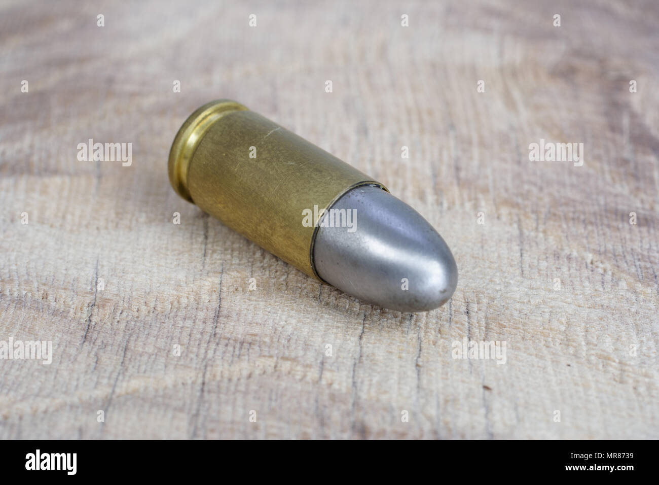 Il calibro 9mm cartuccia su sfondo di legno Foto Stock