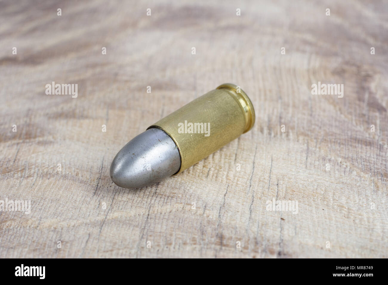 Il calibro 9mm cartuccia su sfondo di legno Foto Stock