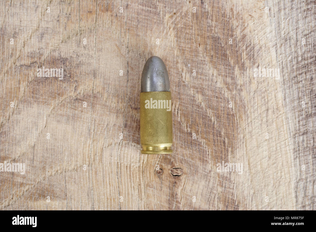 Il calibro 9mm cartuccia su sfondo di legno Foto Stock