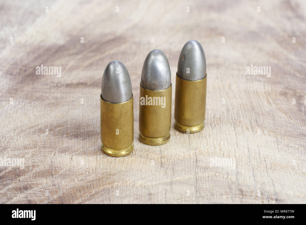 Il calibro 9mm cartuccia su sfondo di legno Foto Stock