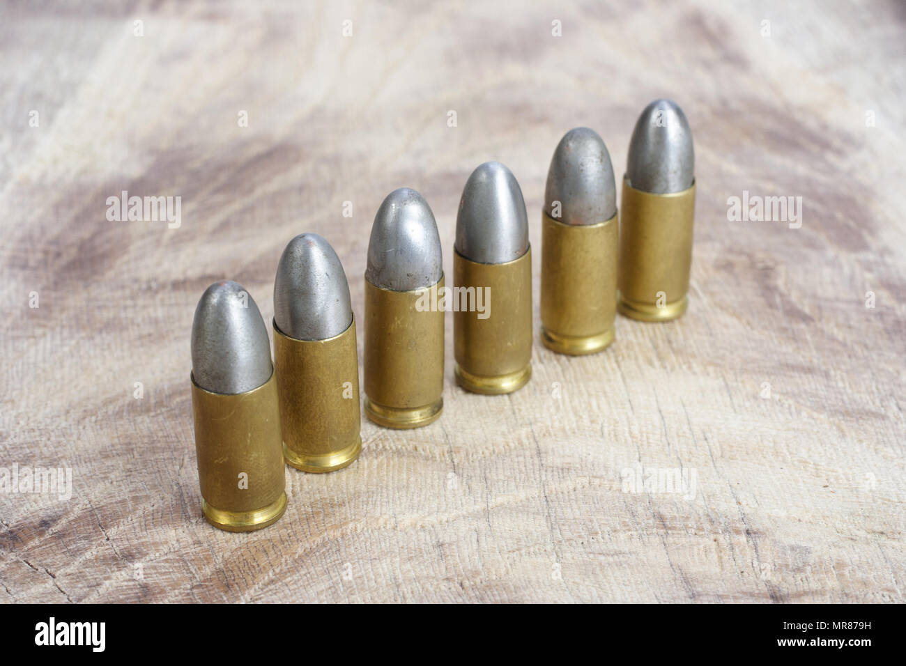 Il calibro 9mm cartuccia su sfondo di legno Foto Stock